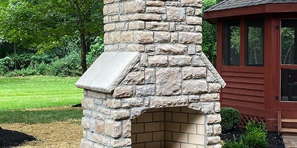 Round Grove Mezzo stone outdoor fireplace installed on custom paver patio in Central Ohio