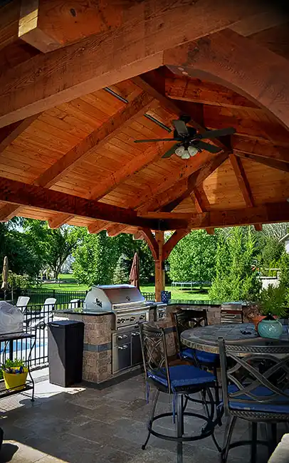 Cedar pavilion with outdoor kitchen and stainless steel grill with granite countertops in Central Ohio backyard