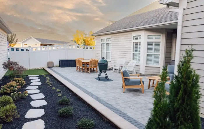 Custom Unilock Beacon Hill Smooth paver patio in Lewis Center, Ohio, with outdoor seating, natural stone walkway, landscaped garden beds, and privacy fencing.
