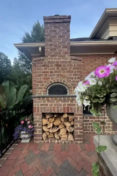 Brick and natural stone outdoor fireplace with seating area designed in New Albany Ohio