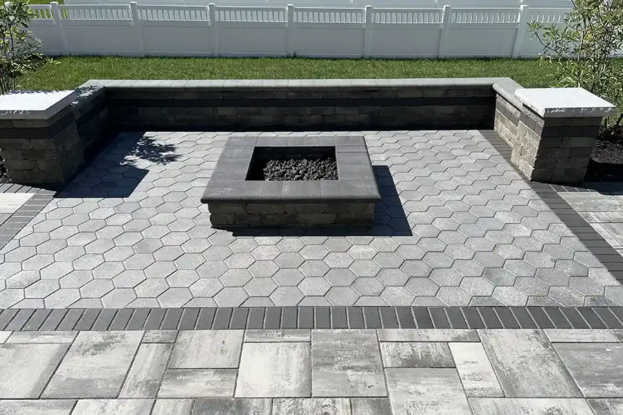 Custom Unilock Beacon Hill Smooth Granite Fusion paver patio in New Albany Ohio with hex paver inlay, limestone seating walls, and gas fire pit.